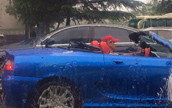 成都　雨の中でオープンカーを走らせる男性