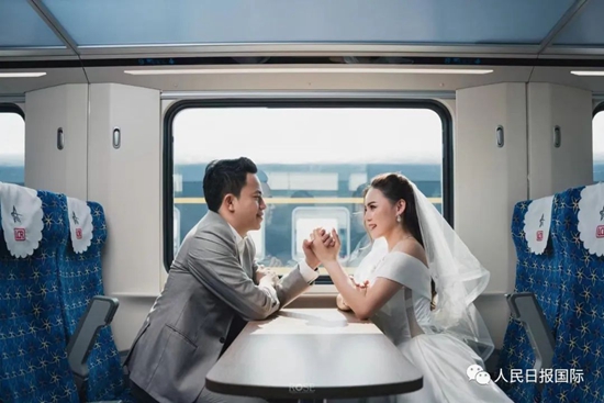 ラオスの新年を祝う「水かけ祭」の時期に、中国ラオス鉄道の高速列車「瀾滄号」の中でウェディングフォトを撮影するカップル。
