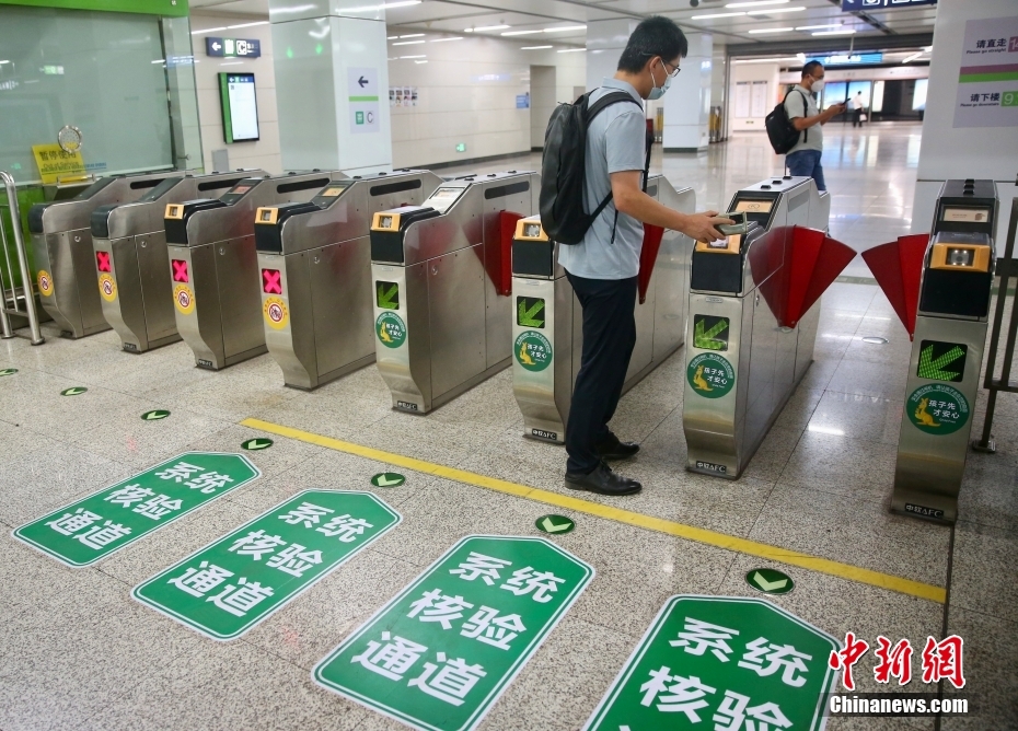 北京地下鉄七里庄駅で、乗車QRコードをかざして改札を通る乗客（6月9日撮影・易海菲）。