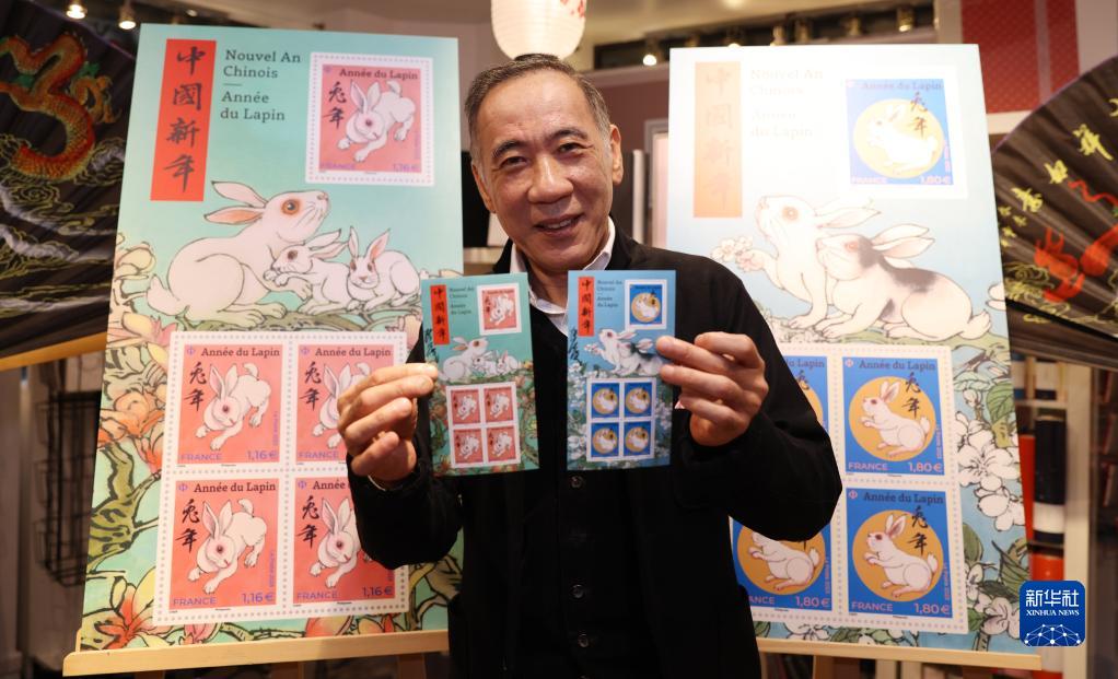 仏パリで開かれた切手発行式で、自らデザインした「兎年」干支特別記念切手を見せる陳江洪氏（1月14日撮影・高静）。
