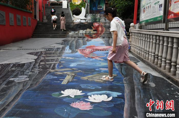 竜門浩老街の立体的な絵が描かれた地面で遊ぶ女の子（撮影・周毅）。
