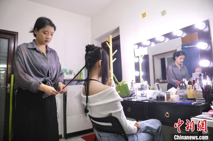 四川省成都市にある漢服メイク・ヘアセットスタジオで、モデルのヘアセットをする漢服メイク・ヘアセットアーティストの李金芝さん（写真左、9月26日撮影・王磊）。